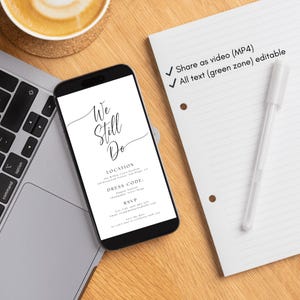 May include: A smartphone displays a wedding invitation with the text "We Still Do." A white pen and lined paper are next to the phone. A cup of coffee and a laptop keyboard are also visible on a wooden surface.