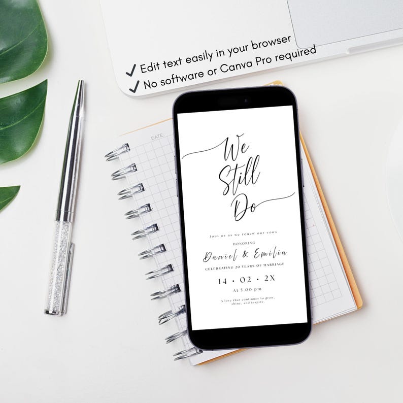 May include: A smartphone displays a wedding anniversary invitation with the text "We Still Do." The phone rests on a notepad next to a pen. The invitation includes the names Daniel & Emilia and the date 14.02.2X.