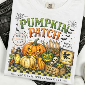 Puede incluir: Una camiseta blanca con un gráfico colorido de Halloween con el texto PUMPKIN PATCH, TRICK FROM THE TREAT, SPOOKY SWEETS, HAUNTED HILL, WICKED SWEETS y GHOSTS WITCHES MONSTERS. El diseño incluye calabazas, un farol y calaveras.