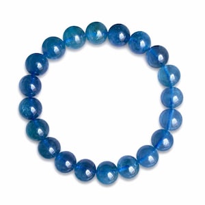 Puede incluir: Una pulsera elástica circular compuesta por numerosas cuentas de piedras preciosas azules, pulidas y translúcidas. Cada cuenta presenta una superficie lisa y redondeada con variaciones sutiles en la intensidad del color y claridad.