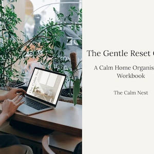 May include: A laptop displays a workbook titled "The Calm Nest" with the text "The Gentle Reset Guide" and "A Calm Home Organisation Workbook." The laptop is on a wooden surface near a window with green plants. The image promotes home organization.