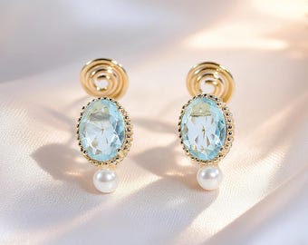 Pendientes ovalados de clip azul aguamarina con perla pequeña y espiral antimosquitos invisible. Estilo barroco vintage. Delicado regalo de San Valentín para primavera.