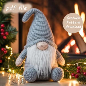 Op de afbeelding: Een handgemaakte gehaakte kabouter met een grijze hoed, een beige neus en een lange witte baard. De kabouter heeft grijze armen en benen en zit. De afbeelding bevat de tekst "pdf file" en "Crochet Pattern download".