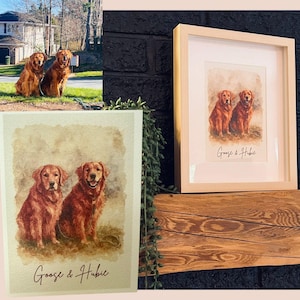 May include: A framed watercolour print of two golden retrievers, with the text "Goose & Hubie" beneath. The print is displayed on a wooden surface, next to a smaller, unframed print of the same image.