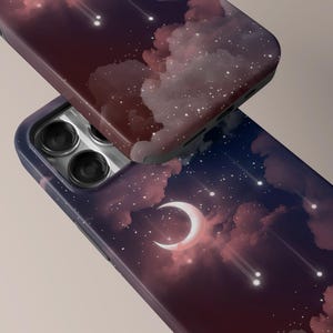 Puede incluir: Dos fundas de tel&eacute;fono con un dise&ntilde;o celestial. Una funda es parcialmente visible, mostrando un tono burdeos oscuro, mientras que la otra muestra un cielo nocturno con una luna creciente, nubes y estrellas fugaces. Las fundas tienen un acabado brillante.
