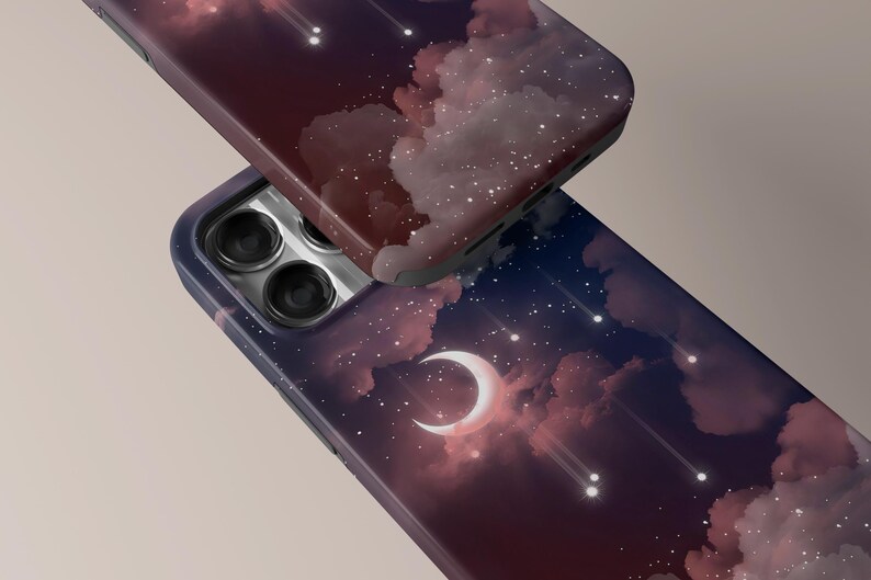Puede incluir: Dos fundas de tel&eacute;fono con un dise&ntilde;o celestial. Una funda es parcialmente visible, mostrando un tono burdeos oscuro, mientras que la otra muestra un cielo nocturno con una luna creciente, nubes y estrellas fugaces. Las fundas tienen un acabado brillante.