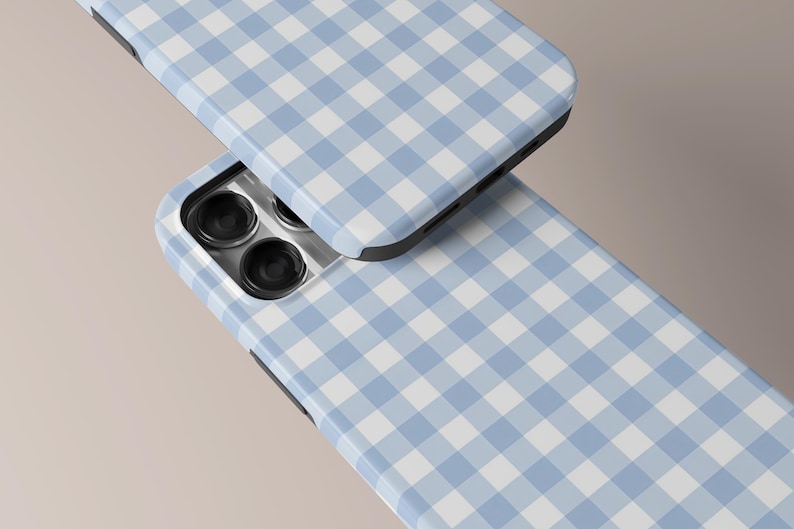 May include: Two phone cases with a light blue and white gingham pattern. The cases are shown at an angle, with the camera lenses visible on one. The cases have a black border and a glossy finish, creating a clean and modern look.