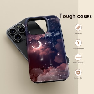 Puede incluir: Una funda de tel&eacute;fono inteligente con un dise&ntilde;o celestial que presenta una luna creciente, estrellas y nubes en tonos de rosa, morado y azul. La funda se muestra encima de un tel&eacute;fono inteligente negro. El texto en la funda dice "Tough cases".