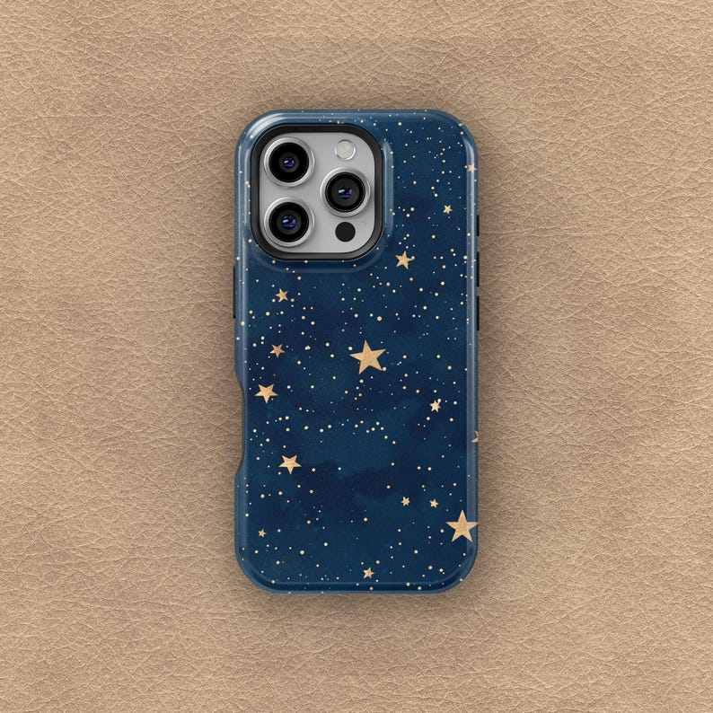 May include: A navy blue phone case with a starry night design. The case features a pattern of gold stars and white dots against a dark blue background. The phone case has a camera cutout and side buttons.