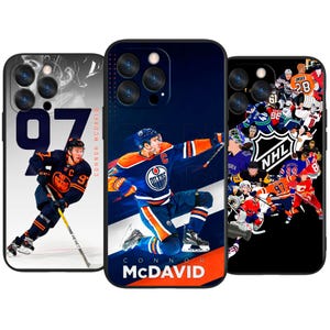 May include: Three phone cases with hockey-themed designs. One case features Connor McDavid in an Oilers uniform with the number 97. Another case shows McDavid in action. The third case has a collage of NHL players and logos.