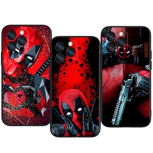 Puede incluir: Tres fundas negras para teléfono con ilustraciones de Deadpool. Las fundas muestran a Deadpool en varias poses, incluyendo un diseño geométrico, un signo de paz y sosteniendo un arma. Los colores dominantes son el rojo y el negro, con un efecto de salpicadura en una funda.