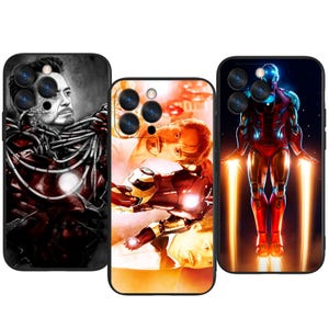 Może przedstawiać: Trzy etui na telefon z grafiką Iron Mana. Etui prezentują różne obrazy superbohatera, w tym czarno-biały portret, dynamiczną pozę i pełną ilustrację z promieniami energii. Etui mają czarne obramowania.