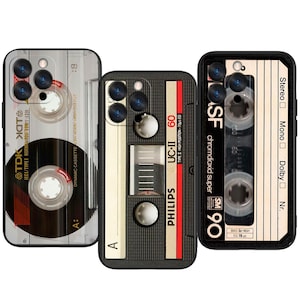 Może przedstawiać: Trzy etui na telefon z wzorami kaset retro. Jedno etui przedstawia taśmę TDK, drugie Philips UC-II 60, a trzecie BASF chromdioxid super 90. Każde etui ma czarną obwódkę i przezroczyste tło.