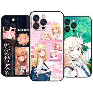 Puede incluir: Tres fundas para teléfono con ilustraciones de estilo anime. Las fundas muestran un personaje rubio con ojos rojos en varias poses. Una funda tiene texto japonés y el nombre "MARI". Las otras fundas tienen fondos rosas y verdes.