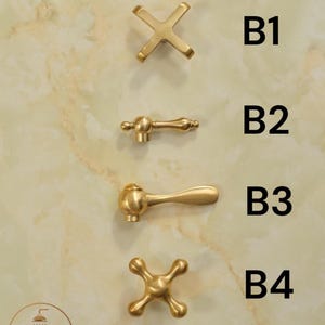 Puede incluir: Cuatro manijas de grifo de metal dorado etiquetadas de B1 a B4. B1 es una manija en forma de cruz, B2 es una palanca delgada, B3 es una palanca curva y B4 es una manija en cruz redondeada. El texto CHOOSE YOUR HANDLES y BRASSLUX CRAFTS es visible.