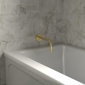 Könnte beinhalten: Ein goldfarbener, gebogener Wasserhahn ist an einer weißen Badewanne montiert. Der Wasserhahn ist an einer Wand mit grau marmorierten Fliesen befestigt. Die Badewanne ist weiß und hat ein schlichtes, modernes Design.