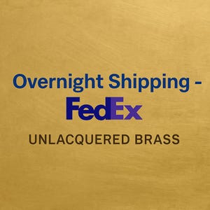 May include: A gold-colored background with the text "Overnight Shipping - FedEx" in blue and purple. Below, the text "UNLACQUERED BRASS" is in a dark brown color.