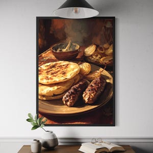 May include: A framed painting depicts a meal on a plate, including grilled flatbread, grilled onions, and two grilled meat sausages. A small bowl of white sauce is visible. The painting is displayed above a wooden table with a vase and a book.