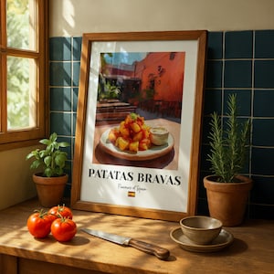 May include: A framed art print featuring a plate of patatas bravas with red sauce and a small bowl of dip. The text reads PATATAS BRAVAS, Flavours of Spain, and includes a small Spanish flag icon. The print is displayed in a wooden frame.