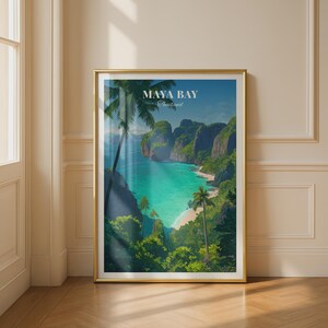 May include: A vertical rectangular wall art print in a gold frame featuring a landscape illustration of Maya Bay, Thailand. The image depicts turquoise water, sandy beaches, lush green cliffs, and palm trees with the text MAYA BAY Thailand.