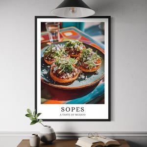 May include: A framed print featuring four sopes, a traditional Mexican dish. The sopes are on a blue plate and topped with shredded lettuce, cheese, and a red sauce. The print includes the text "Sopes, A Taste of Mexico."
