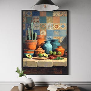 May include: A framed still life painting featuring terracotta pots, blue vases, and a cactus. The painting includes avocados, limes, and chili peppers on a table with a tiled background. A black lamp hangs above the painting.