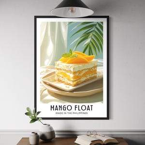 Puede incluir: Impresión enmarcada de un postre de mango float. El postre en capas está cubierto con rodajas de mango y hojas de menta. El texto "MANGO FLOAT MADE IN THE PHILIPPINES" se muestra debajo del postre.