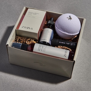 Peut inclure: Une bo&icirc;te-cadeau remplie de produits de beaut&eacute;, dont un savon pour le visage et le corps, un s&eacute;rum pour le visage, une brume pour le visage, un baume &agrave; l&egrave;vres et une bombe de bain. La bo&icirc;te est blanche avec les mots "Conscious Beauty" imprim&eacute;s en bas. Tous les produits sont de la marque "ZAWINA."