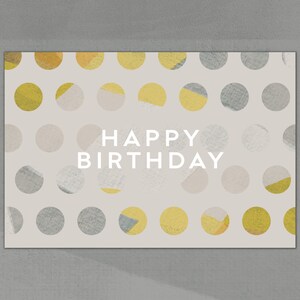 Puede incluir: Una tarjeta beige con un patr&oacute;n de lunares en tonos grises y amarillos. El texto "HAPPY BIRTHDAY" est&aacute; impreso en blanco en el centro de la tarjeta.