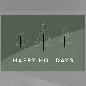 Op de afbeelding: Een groene kerstkaart met een eenvoudig ontwerp van drie gestileerde bomen en de tekst "HAPPY HOLIDAYS".