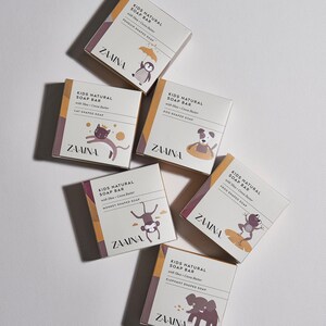 May include: Six square boxes of Zaaina Kids Natural Soap Bar with Shea and Cocoa Butter. Each box features a unique animal illustration including a penguin, cat, dog, monkey, frog, and elephant, with text identifying the specific animal-shaped soap.