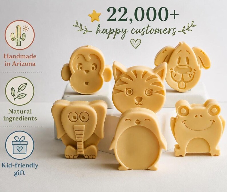 May include: Six light yellow animal-shaped soaps featuring a monkey, cat, dog, elephant, penguin, and frog. The text 22,000+ happy customers is displayed at the top, with icons for handmade in Arizona, natural ingredients, and kid-friendly gift.
