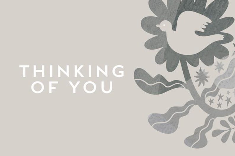 May include: A greeting card with the text "THINKING OF YOU" in white. The card features a dove and floral design in shades of gray on a light beige background. The design includes a dove, flowers, and stars.