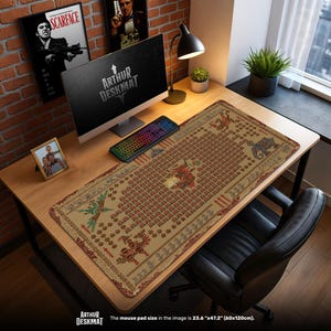 Pode incluir: Um tapete de mesa bege com um padrão detalhado, com elementos vermelhos, verdes e castanhos. O tapete, medindo 60cm x 120cm, está colocado numa secretária de madeira com um computador, teclado e candeeiro. O texto "ARTHUR DESKMAT" é visível.