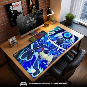 Könnte beinhalten: Eine große, rechteckige Schreibtischunterlage mit einem blau-weißen Lucario-Design. Die Unterlage, mit den Maßen 60cm x 120cm, liegt auf einem Holztisch mit Computer, Tastatur und Zubehör. Der Text "ARTHUR DESKMAT" ist sichtbar.