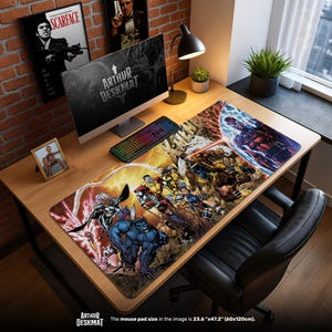 Pode incluir: Um tapete de secretária retangular grande com uma ilustração de banda desenhada colorida. O tapete, medindo 60cm x 120cm, mostra vários personagens de super-heróis em ação. As palavras "ARTHUR DESKMAT" estão impressas no tapete. Um computador, teclado e candeeiro de secretária também são visíveis.