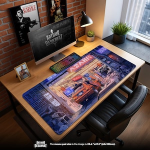 May include: A large rectangular desk mat with a detailed illustration of a city scene, featuring cars and buildings in shades of orange, blue, and purple. The mat is 23.6" x 47.2" (60x120cm) and has the text "AZAHI" and "ARTHUR DESKMAT" printed on it. The desk mat is on a wooden desk.