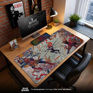 May include: A rectangular desk mat featuring a colorful illustration of Spider-Man characters in action. The mat, measuring 23.6" x 47.2", has a light background with various figures in red, blue, and black. The text "ARTHUR DESKMAT" is visible.