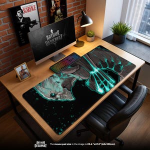 Può includere: Un tappetino da scrivania nero con un design grafico turchese e grigio, un computer e una tastiera. Il tappetino da scrivania misura 60 cm x 120 cm. Il testo "ARTHUR DESKMAT" è visibile. La scrivania è in legno.