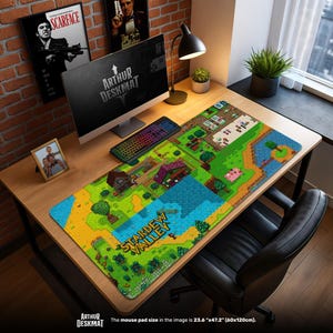 May include: A large rectangular desk mat with a pixelated landscape design and the text "STARDEW VALLEY". The mat measures 60cm x 120cm. A computer, keyboard, and other desk accessories are on the wooden desk. The desk mat is a vibrant green, blue, and yellow.