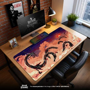 May include: A large rectangular mouse pad with a dragon design. The pad features a black dragon silhouette against a backdrop of orange clouds and a setting sun. The text "ARTHUR DESKMAT" is visible. The pad measures 23.6" x 47.2".