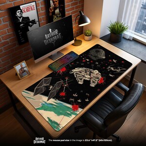 Könnte beinhalten: Eine schwarze Schreibtischunterlage mit Star Wars-Motiv, die den Millennium Falken, TIE-Jäger und den Todesstern in einer Weltraumszene zeigt. Die Matte misst 60cm x 120cm und trägt den Schriftzug "ARTHUR DESKMAT".