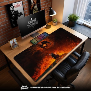 May include: A large desk mat with a fantasy design, measuring 60cm x 120cm. The mat features a fiery scene in shades of orange, red, and black. The text "ARTHUR DESKMAT" is visible. The desk mat is on a wooden desk with a computer and keyboard.