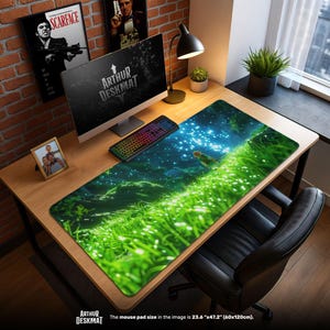 May include: A large rectangular desk mat with a vibrant green and blue landscape design. The mat features a detailed illustration of a grassy field with a character and a starry sky. The mat measures 23.6" x 47.2". The text "ARTHUR DESKMAT" is visible.
