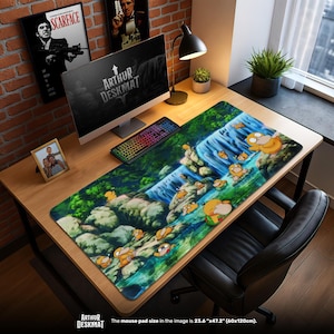 Op de afbeelding: Een groot rechthoekig muismat met een levendige illustratie van een watervalscène met stripfiguren. De mat is 60 cm x 120 cm. De bureau-opstelling omvat een computer, toetsenbord en ingelijste foto's.
