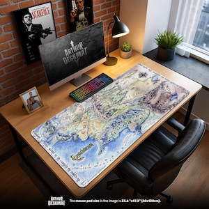 May include: A large rectangular mouse pad with a detailed map design, featuring a variety of colors including blue, green, and brown. The mouse pad is 23.6" x 47.2" and is placed on a wooden desk. The text "ARTHUR DESKMAT" is visible.