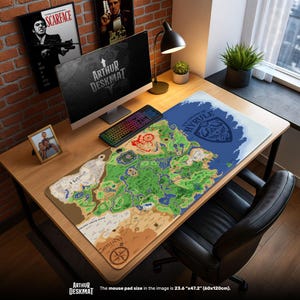 Pode incluir: Um tapete de mesa grande com um mapa de Hyrule de The Legend of Zelda. O tapete é principalmente verde, castanho e azul, com detalhes geográficos. O texto "ARTHUR DESKMAT" é visível. O tapete mede 60cm x 120cm.