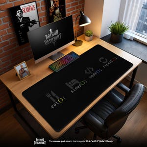 Op de afbeelding: Een zwarte bureaumat met de tekst "eat(); sleep(); code(); repeat();" in het wit. De mat ligt op een houten bureau met een computer, toetsenbord en bureaulamp. De afmeting van de muismat is 60cm x 120cm.