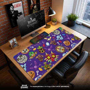 May include: A purple desk mat with a colorful pattern of video game character faces and icons. The mat is 23.6" x 47.2" and sits on a wooden desk with a computer, keyboard, and lamp. The text "ARTHUR DESKMAT" is visible.