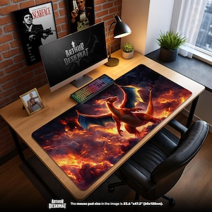 May include: A large rectangular desk mat featuring a fiery dragon design. The dragon is orange and red with blue wings, set against a backdrop of flames and clouds. The mat is 23.6" x 47.2" (60x120cm) and includes the text "ARTHUR DESKMAT".